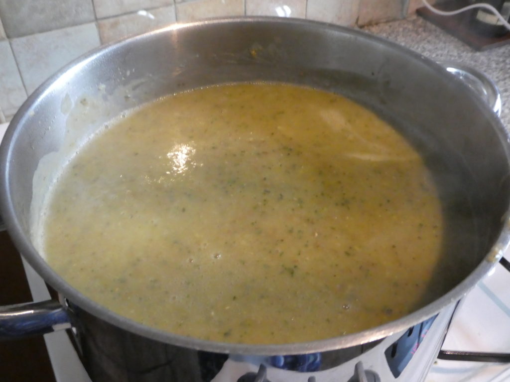 A large steel pot with greeny coloured Courgette Soup