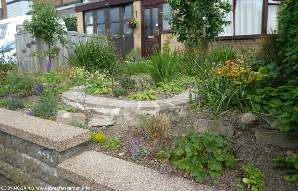 And overview of the garden and the front of the house from the right side of the footpath. It looks a bit bare as the plants were only added recently and it will take time to fill up.