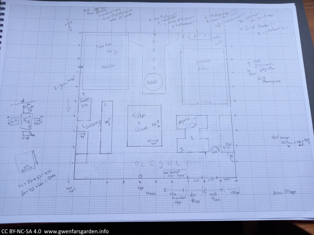 A scaled drawing in pencil on A3 graph paper. There are different shapes representing either buildings or borders, with scribbled writing and measurements.