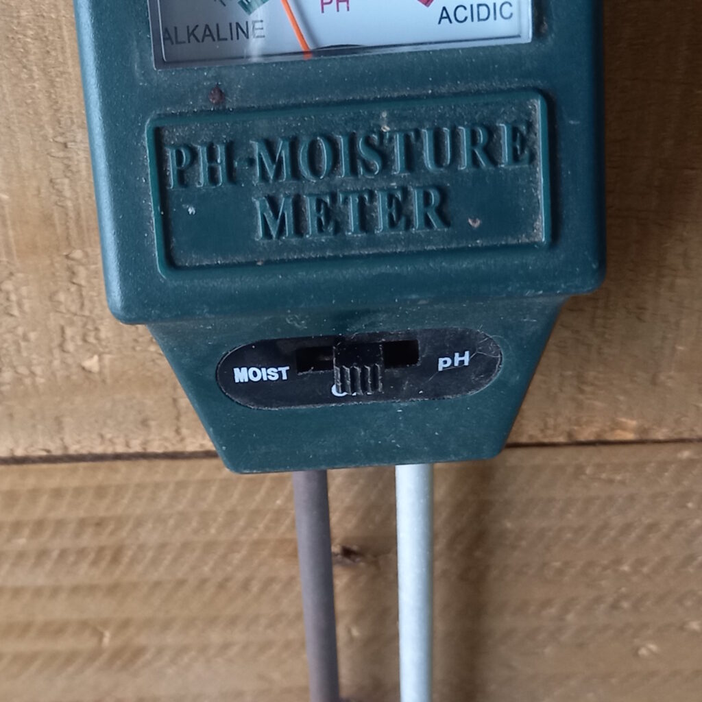 A small gadget with two prongs that goes into the soil, and a reader that measures moisture and soil PH.