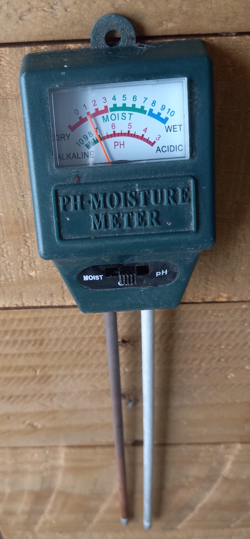 A small gadget with two prongs that goes into the soil, and a reader that measures moisture and soil PH.